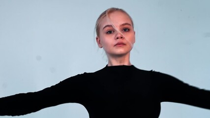 Young blonde woman ballerina spinning and looking in the camera