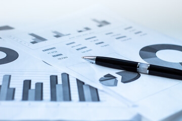 black pen on sheets of paper with graphs and diagrams. Business concepts