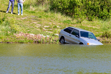 Old car felt into the water because of the some stupid mistake. Upset driver and his wife are...