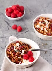 Homemade granola with almonds, pumpkin seeds, sesame seeds, flax and dried cranberries. Decorated with raspberries. Serve with yoghurt