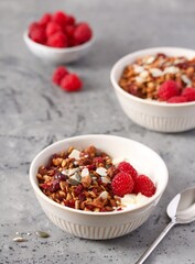 Homemade granola with almonds, pumpkin seeds, sesame seeds, flax and dried cranberries. Decorated with raspberries. Serve with yoghurt