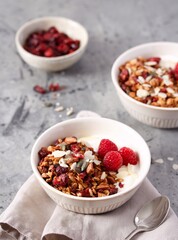 Homemade granola with almonds, pumpkin seeds, sesame seeds, flax and dried cranberries. Decorated with raspberries. Serve with yoghurt