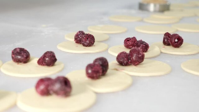 Making stucco dumplings with cherries. Teamwork in the kitchen. Home cuisine.