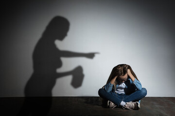 Domestic physical violence, abusing. Scared little caucasian girl, victim sitting close to white...