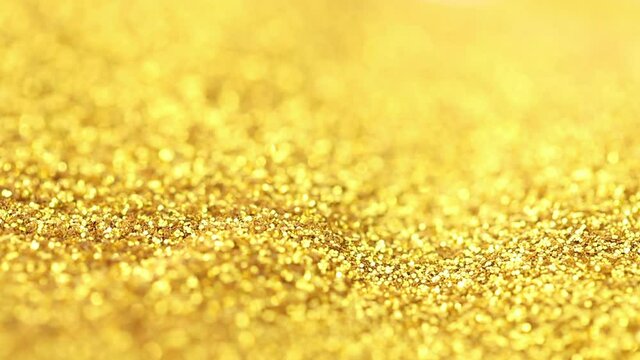 Falling golden fine glitter. Forms a pile of sparkling shimmery gold glitter.