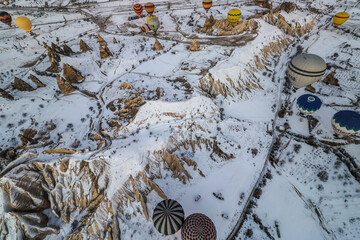 Balloons over snow-capped landscape of Urgup, Turkey