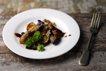 Soft focus. Eringi mushrooms on a plate with spices. Cooked eringi mushrooms.