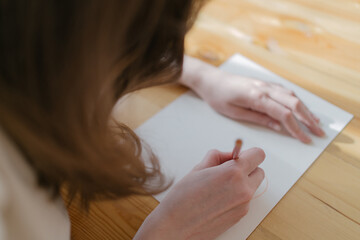 The artist drawing a picture in a cozy interior with a yellow pencil. Creativity and inspiration at work. Home hobbies