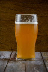 A glass of unfiltered beer with a white foam