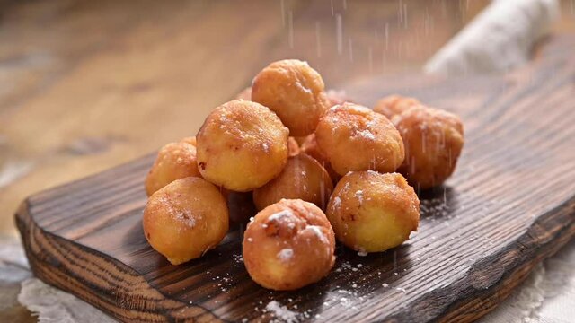Baked castagnole with powdered sugar. Street food, round biscuits with sugar for the carnival of Venice. Traditional sweet pastries during the carnival period in italy. 