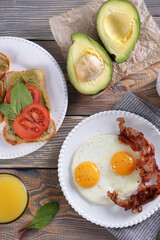 Breakfast with fried eggs and bacon and sandwiches with guacamole sauce