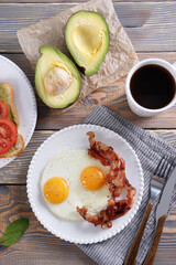 Breakfast with fried eggs and bacon and sandwiches with guacamole sauce