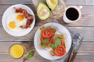 Breakfast with fried eggs and bacon and sandwiches with guacamole sauce