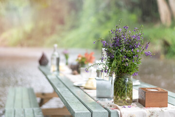 Romance table dinner on creek with flowers for romantic outdoor valentines;s day date background.