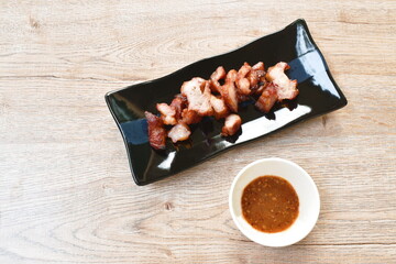 grilled pork neck slice on plate dipping spicy sauce