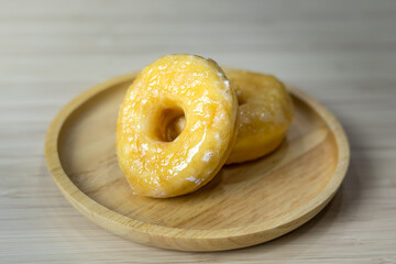 Tasty original icing sugar donuts served on wooden plate. Bakery food close-up photo.