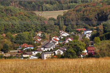 Village in the Palatinate Forest of Germany surrounded by trees changing colors on a late summer day.