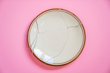 Broken plate on pink background