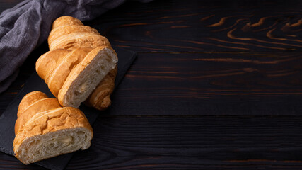 fresh croissants on dark wooden background. French breakfast. Top view flat lay with copy space