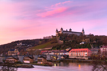 View of Marienberg Fortress and Old Main Bridge, Alte Mainbrucke in Wurzburg at pink sunset, Bavaria, Germany