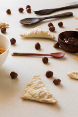 Some nutella hand pies with a wooden spoon and some hazelnut