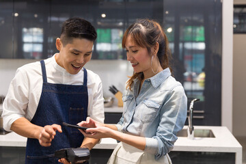Contactless payment. Customer woman using Mobile phone scanning for payment. Woman paying with mobile phone in cafe shop. Mobile payments online shopping.