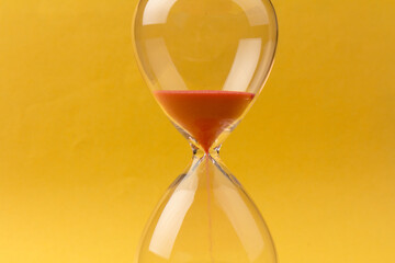 Crystal hourglass on yellow background as a concept of passing time for business term, urgency and outcome of time.