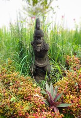 Obraz premium Black statue in flower garden in the morning.