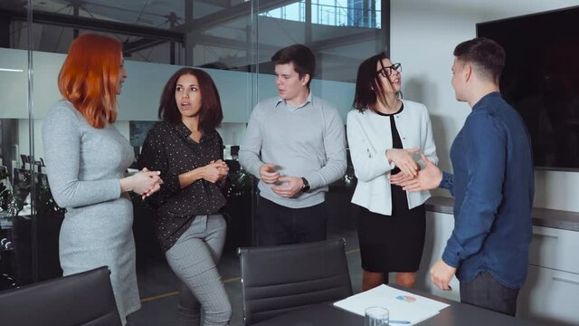 Diverse group of business people standing in office and shaking hands after making profitable deal. Business partners expressing respect after discussing contract. Concept of agreement