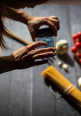 Woman taking food stock photography with her mobile phone.