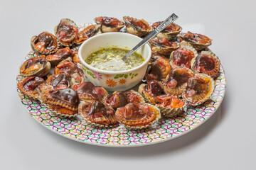 Fresh and delicious boiled​ cockles​ shell with spicy seafood sauce. Steamed cockle Boiled cockles with tasty sauce top view,thai 