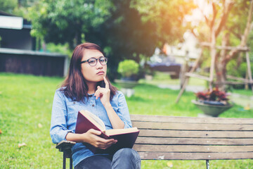 Fototapeta na wymiar Woman reading book on park bench