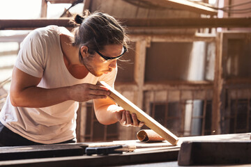 Confident wood worker expert. Young man working at factory. Skilled carpenter