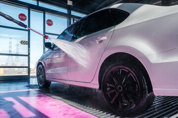 car wash with a spray of pink foam from a pistol