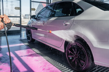 Obraz na płótnie Canvas car wash with a spray of pink foam from a pistol