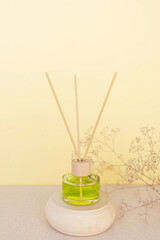 room freshener on a wooden podium on a beige background with delicate flowers. Copy space