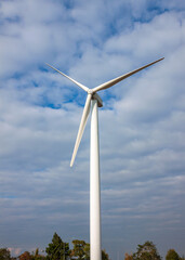 Wind turbine having a large vaned wheel rotated by the wind to generate electricity..