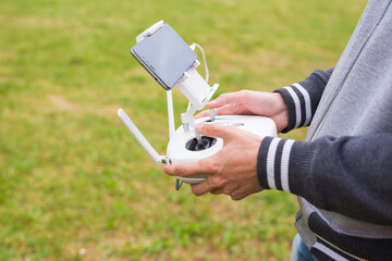 Man Operating Drone Flying or Hovering by Remote Control in Nature