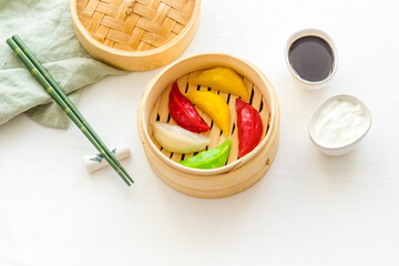 Fototapeta na wymiar Asian steamed dumplings in wooden steamer. Traditional Chinese dim sum set