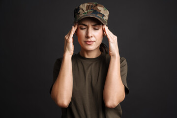 Unhappy soldier woman with headache rubbing her temples