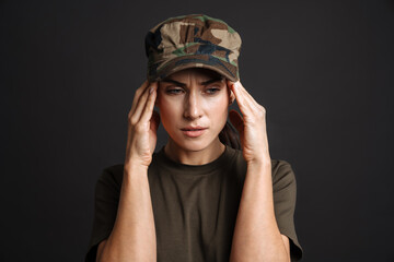 Unhappy soldier woman with headache rubbing her temples