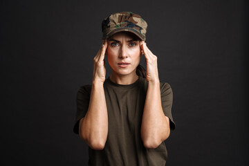 Unhappy soldier woman with headache rubbing her temples