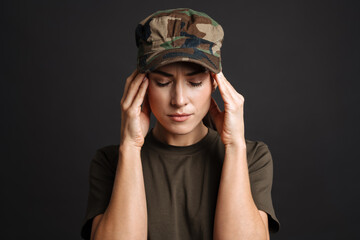 Unhappy soldier woman with headache rubbing her temples