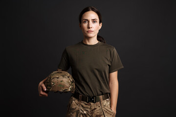 Serious beautiful soldier woman posing with military helmet