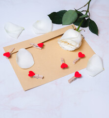 rose with hearts on a paper envelope as a background. valentine's day celebration and eighth march concept