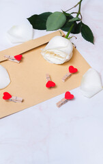 rose with hearts on a paper envelope as a background. valentine's day celebration and eighth march concept