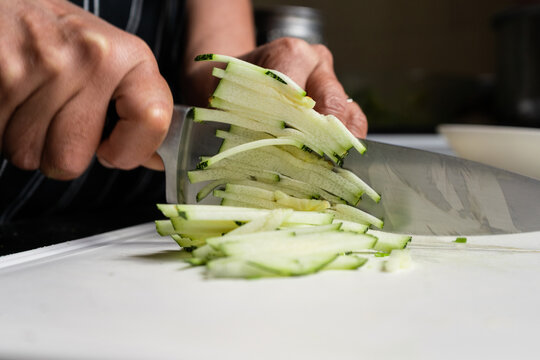 Cook cutting zucchini squash sticks. Close up.