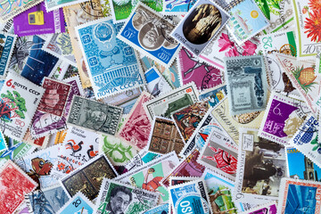 Fototapeta na wymiar Background from old multicolored postage stamps collection from different countries