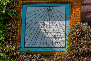 A vertical sundial on a wall in Warwickshire. UK - obrazy, fototapety, plakaty