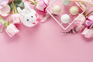 Eggs in white ceramic holder and flowers on pink background. Mock up. Spring Happy Easter holiday card. Top view.